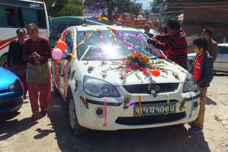 A wedding car decorated with ribbons and flowers
