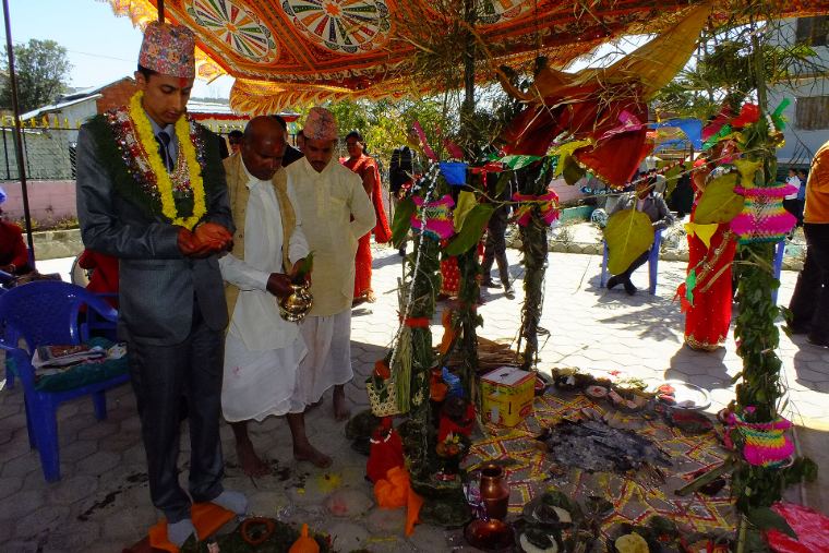A decorated wedding mandap with the couple and priest